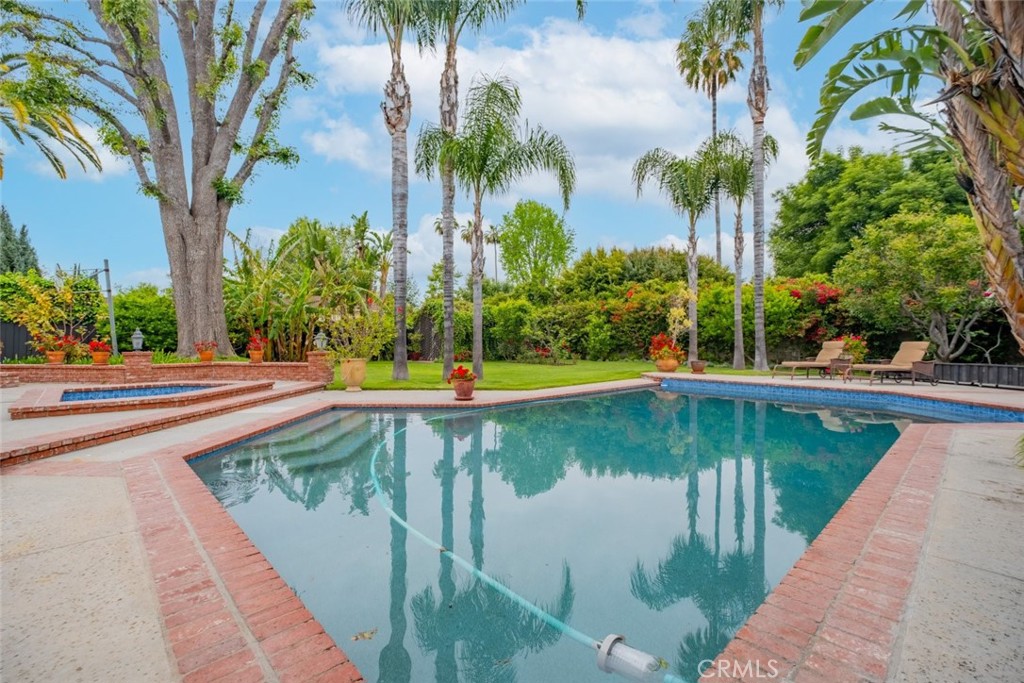15363 Victory Boulevard Van Nuys, CA 91406 - Photo 43 of 52 a view of a swimming pool with a yard and palm trees