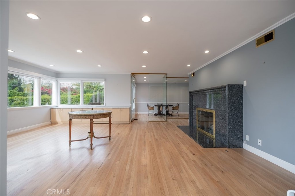 15363 Victory Boulevard Van Nuys, CA 91406 - Photo 5 of 52 a open kitchen with stainless steel appliances a refrigerator a stove a oven a dining table and chairs with wooden floor