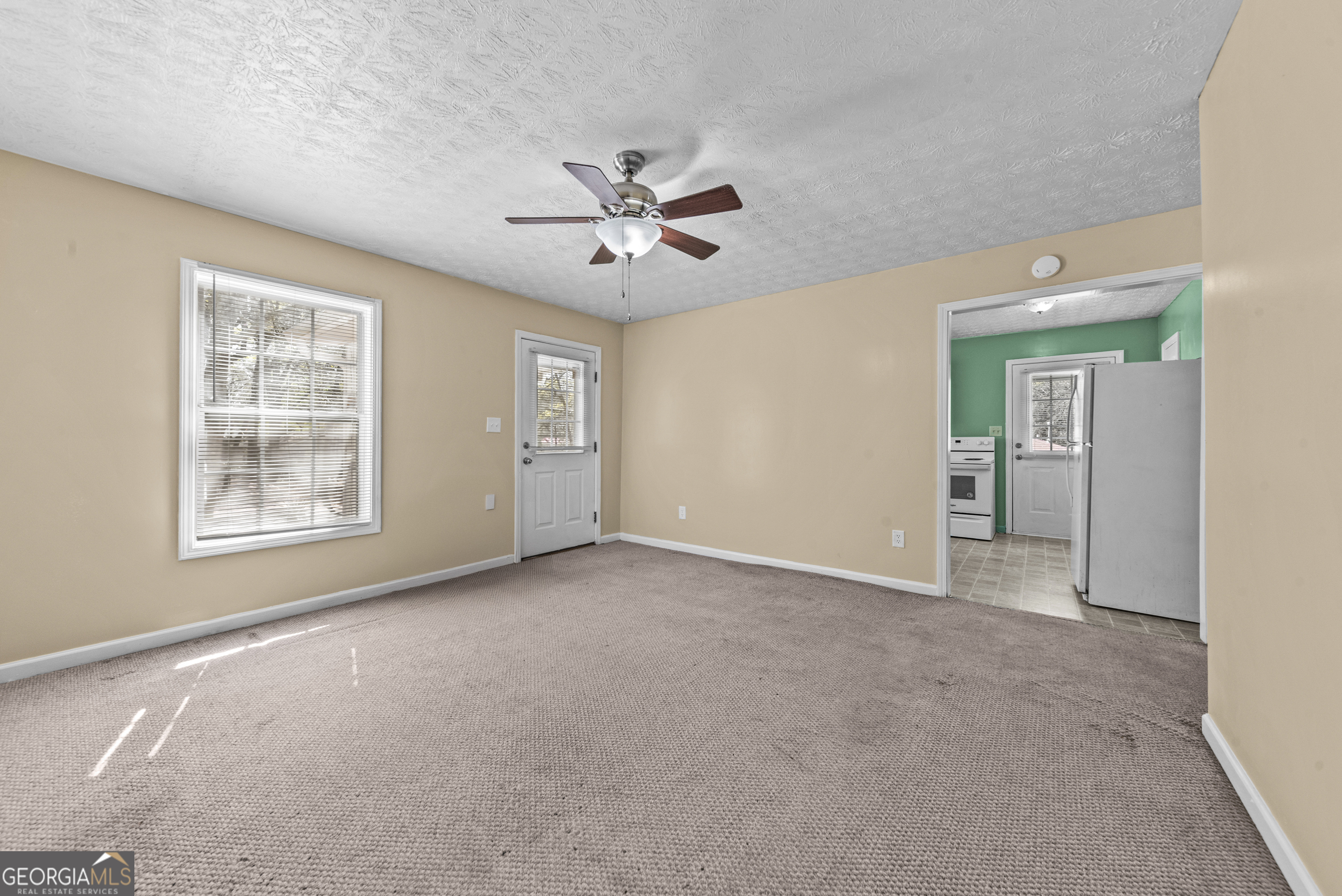 517 Gilmore Street Madison, GA 30650 - Photo 12 of 34 an empty room with chandelier fan and windows