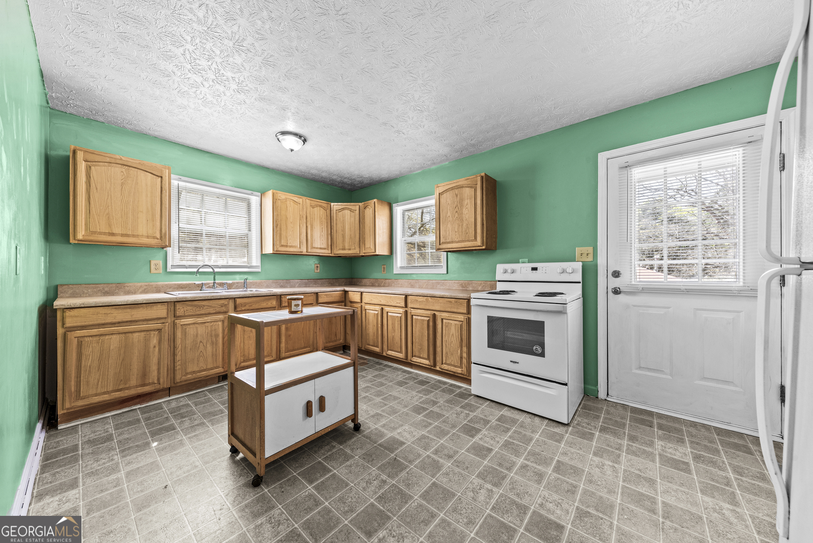 517 Gilmore Street Madison, GA 30650 - Photo 13 of 34 a kitchen with stainless steel appliances a stove sink and cabinets