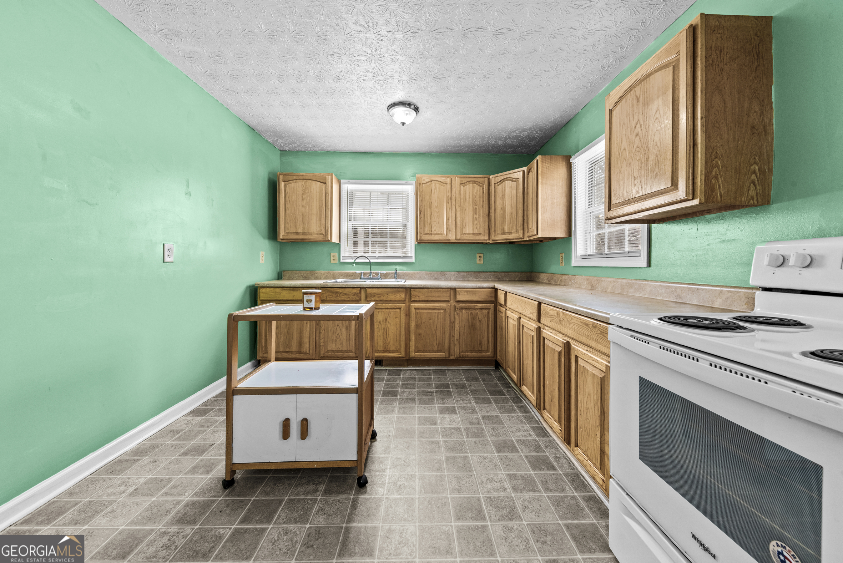 517 Gilmore Street Madison, GA 30650 - Photo 14 of 34 a kitchen with a stove sink and cabinets