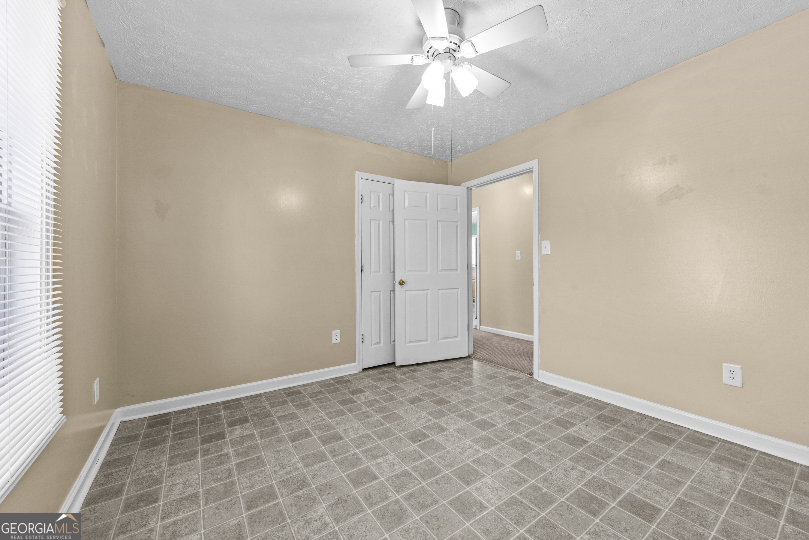 517 Gilmore Street Madison, GA 30650 - Photo 17 of 34 an empty room with a ceiling fan and a window