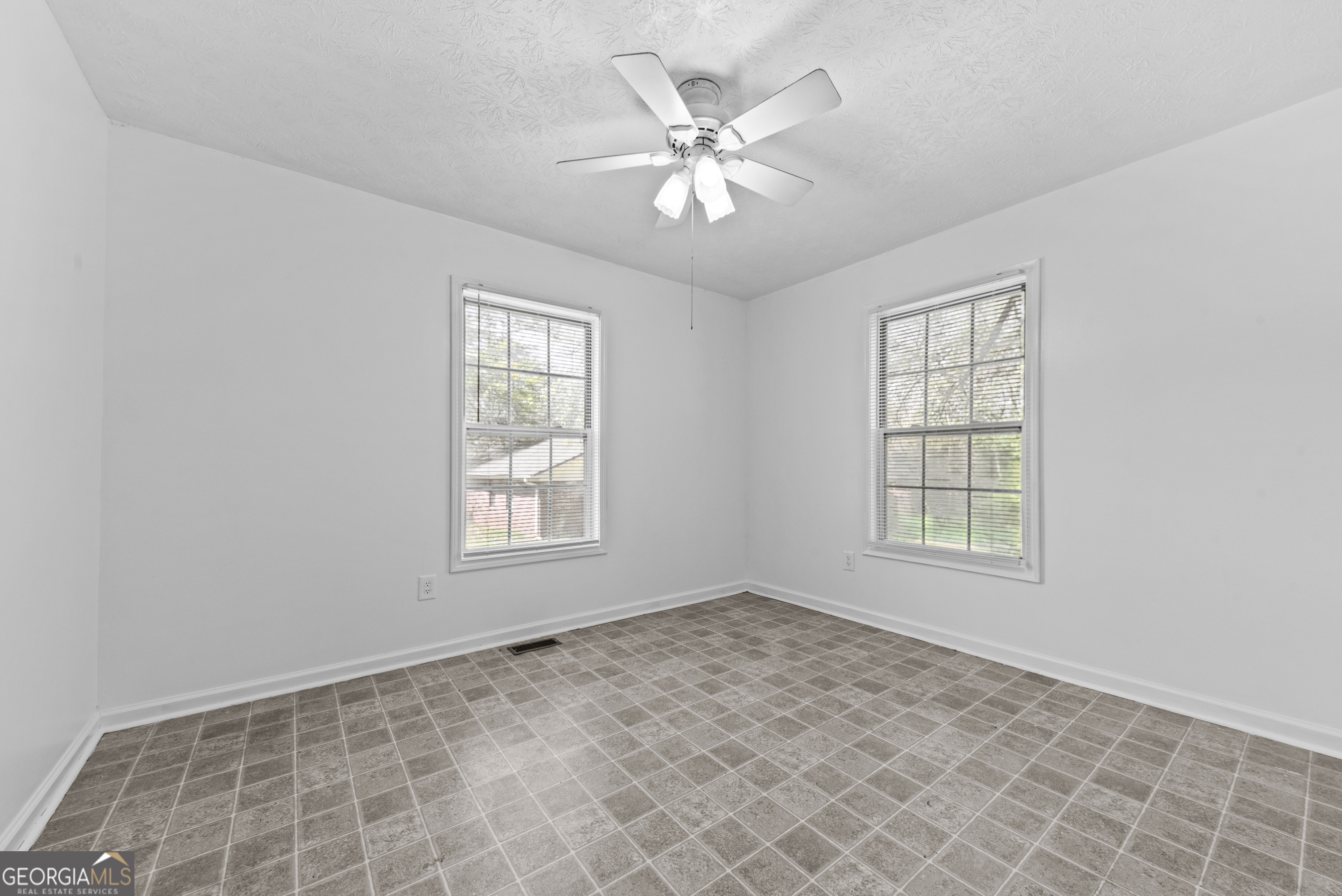 517 Gilmore Street Madison, GA 30650 - Photo 20 of 34 an empty room with chandelier fan and windows