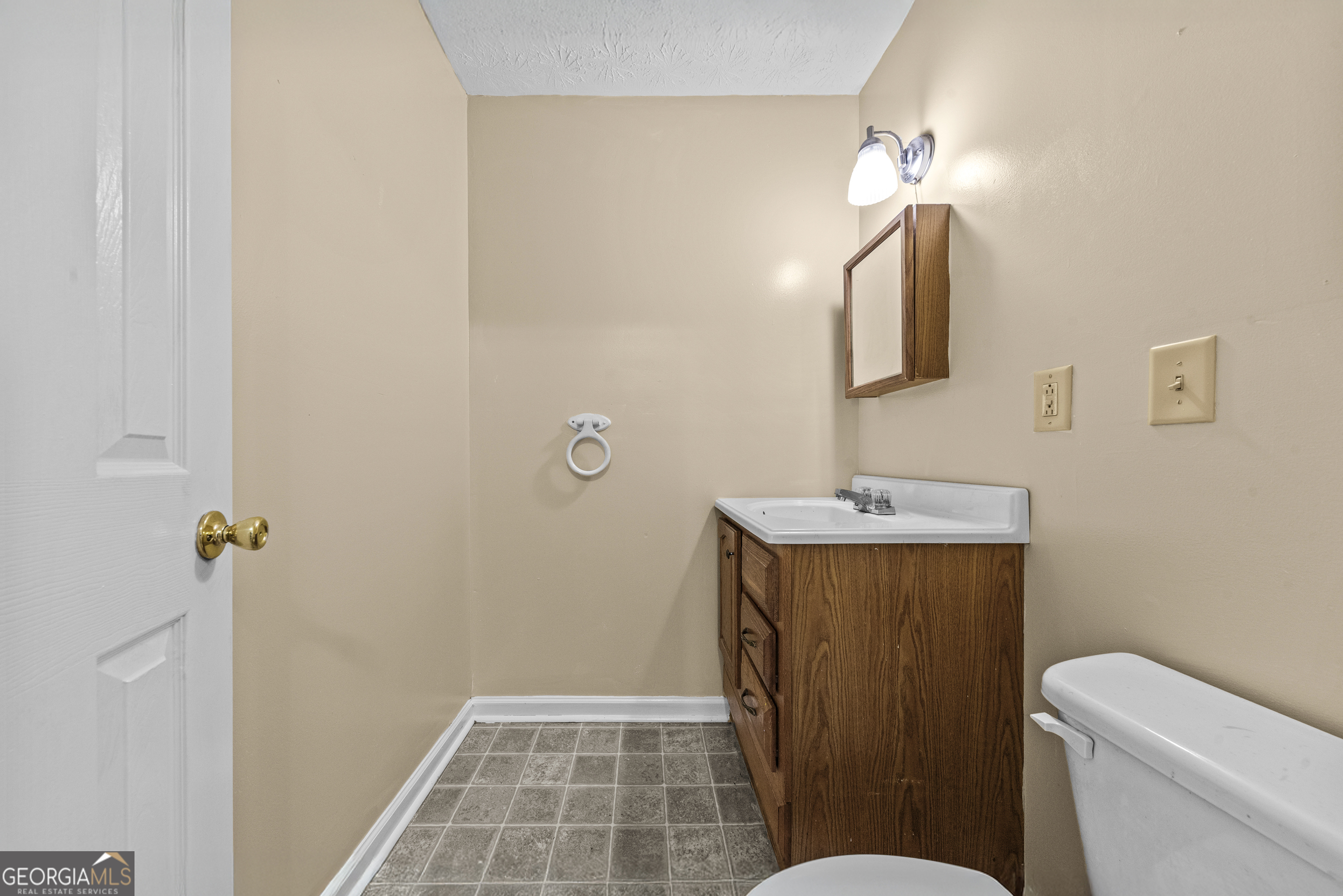 517 Gilmore Street Madison, GA 30650 - Photo 25 of 34 a bathroom with a sink a toilet a mirror and shower