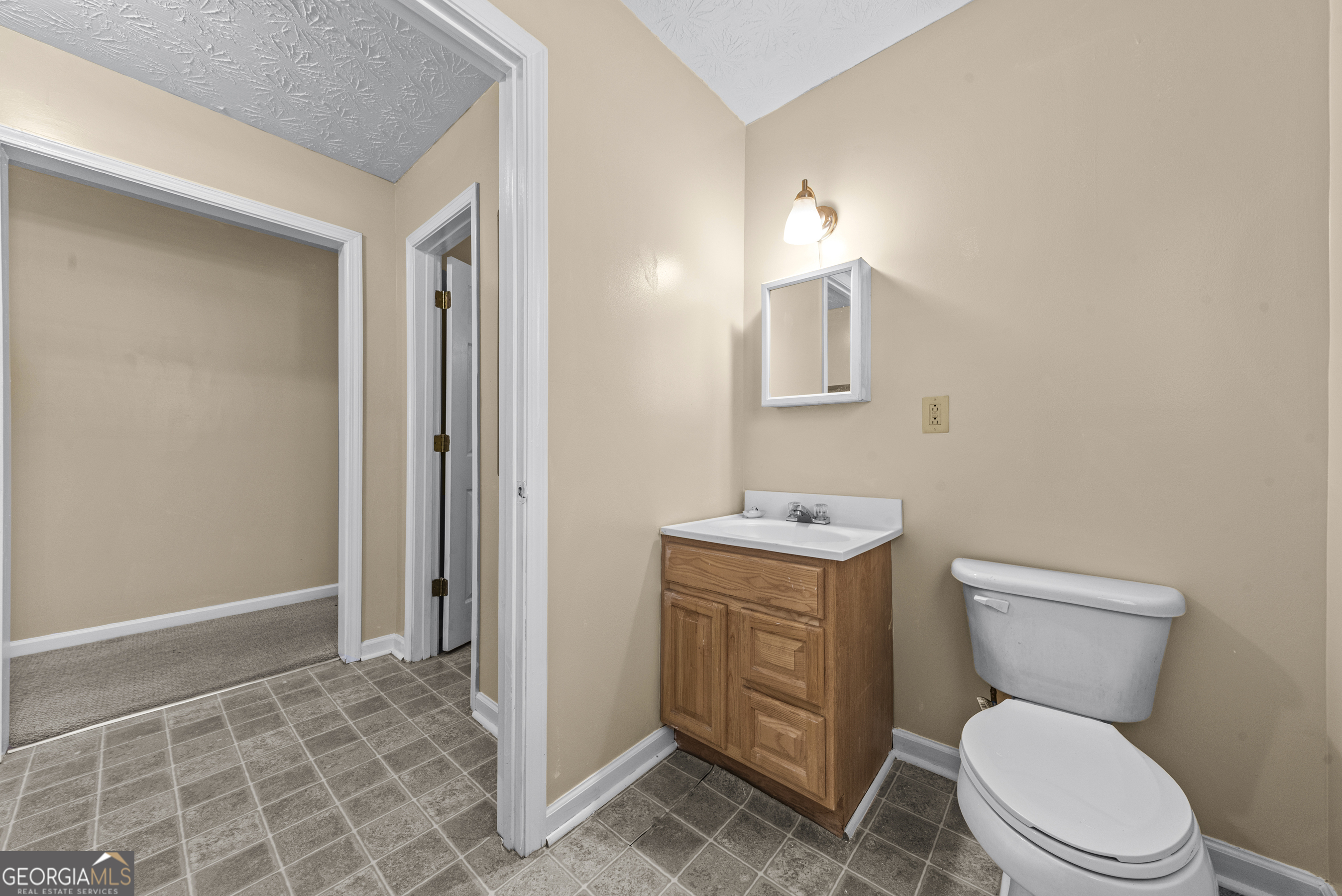 517 Gilmore Street Madison, GA 30650 - Photo 27 of 34 a bathroom with a toilet a sink and mirror