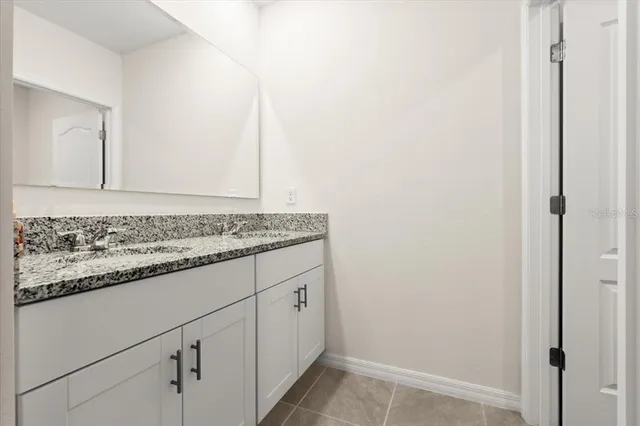 a bathroom with a granite countertop sink and vanity