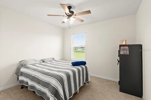 a bedroom with a bed and a ceiling fan