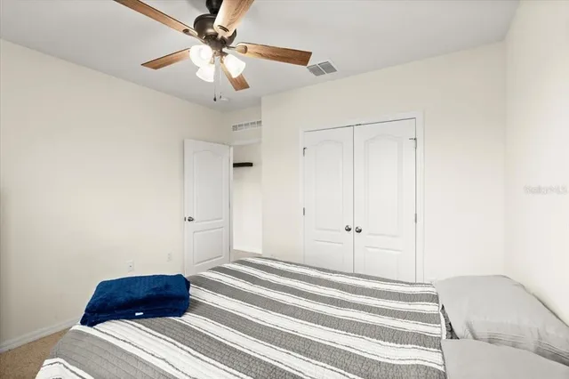a bedroom with a bed and a ceiling fan