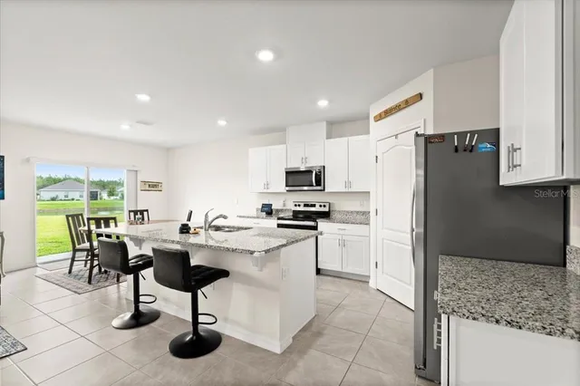 a kitchen with refrigerator and chairs