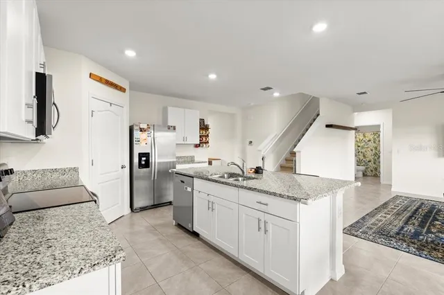 a kitchen with stainless steel appliances granite countertop a sink and a stove