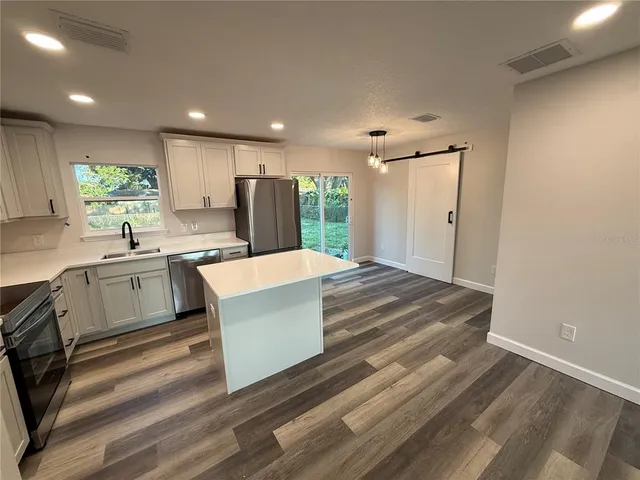 a large kitchen with kitchen island a sink stainless steel appliances and cabinets