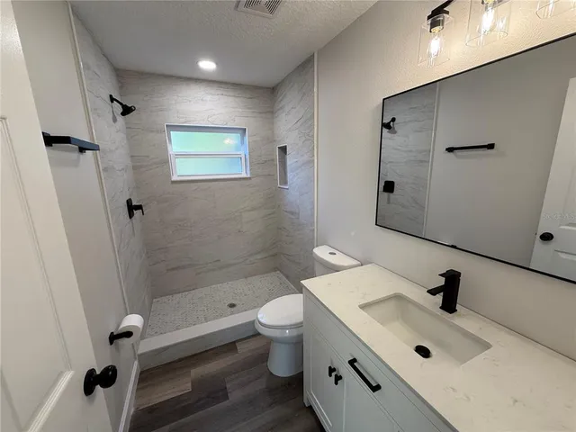 a bathroom with a sink a toilet and shower