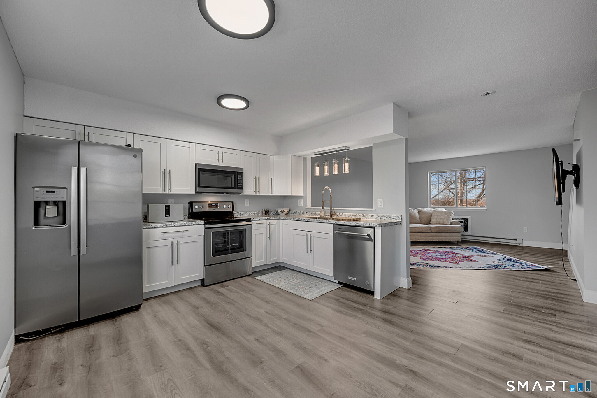 24 Blue Ridge Drive, Unit K12 Waterbury, CT 06704 - Photo 2 of 15 a kitchen with granite countertop a refrigerator oven a sink dishwasher and white cabinets with wooden floor