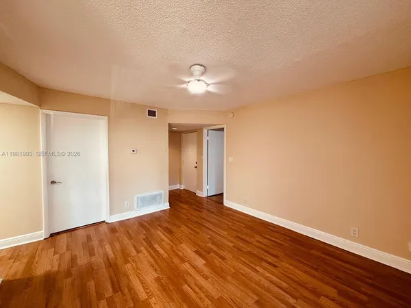 a view of empty room with wooden floor