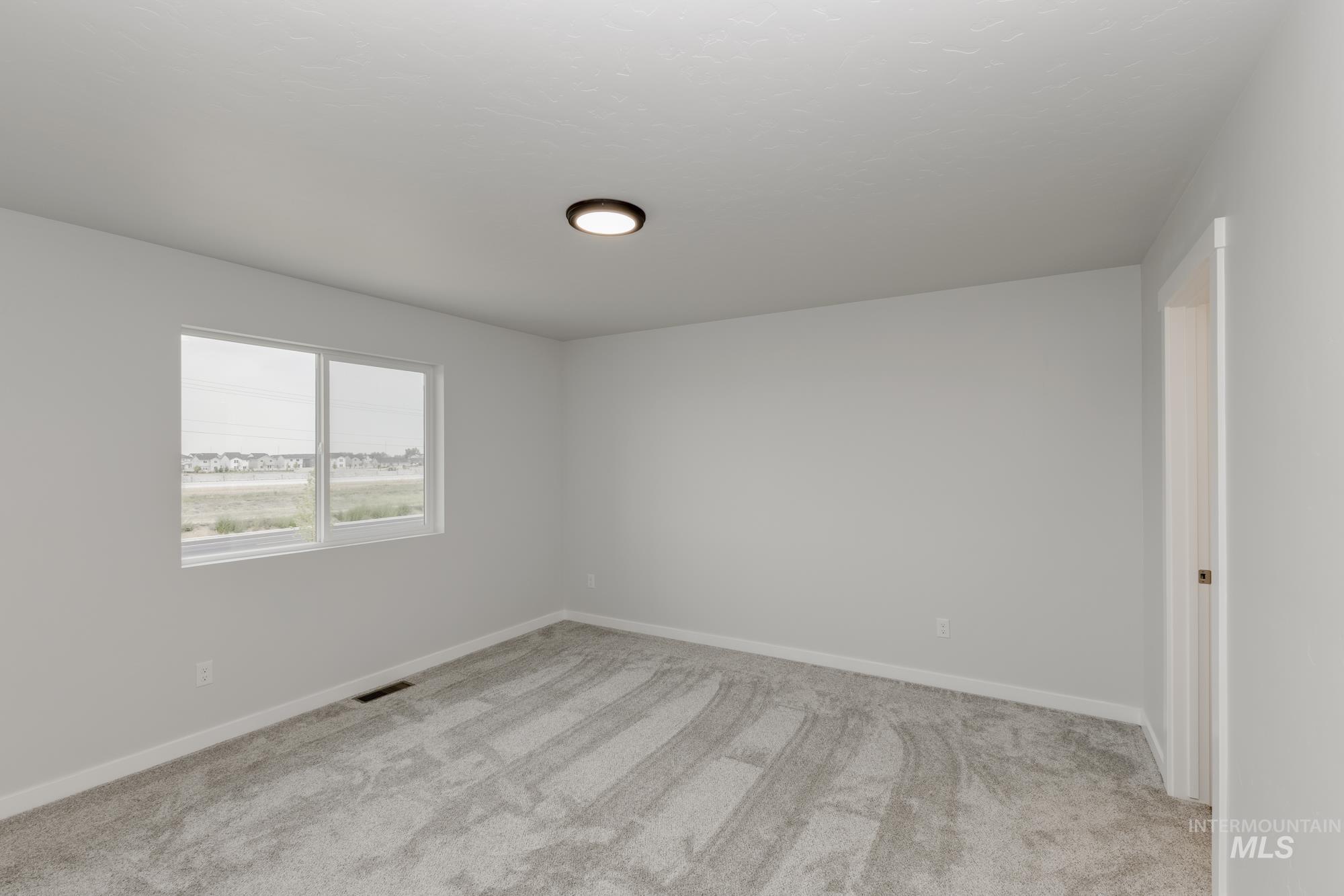10873 Rutland Street Caldwell, ID 83605 - Photo 17 of 19 Unfurnished room with light carpet and baseboards
