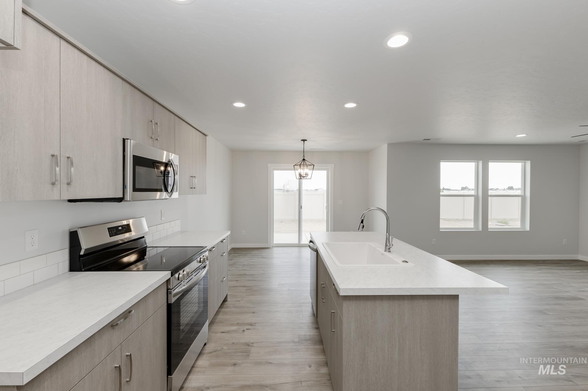 10873 Rutland Street Caldwell, ID 83605 - Photo 4 of 19 Kitchen with appliances with stainless steel finishes, light brown cabinets, decorative light fixtures, light countertops, and recessed lighting