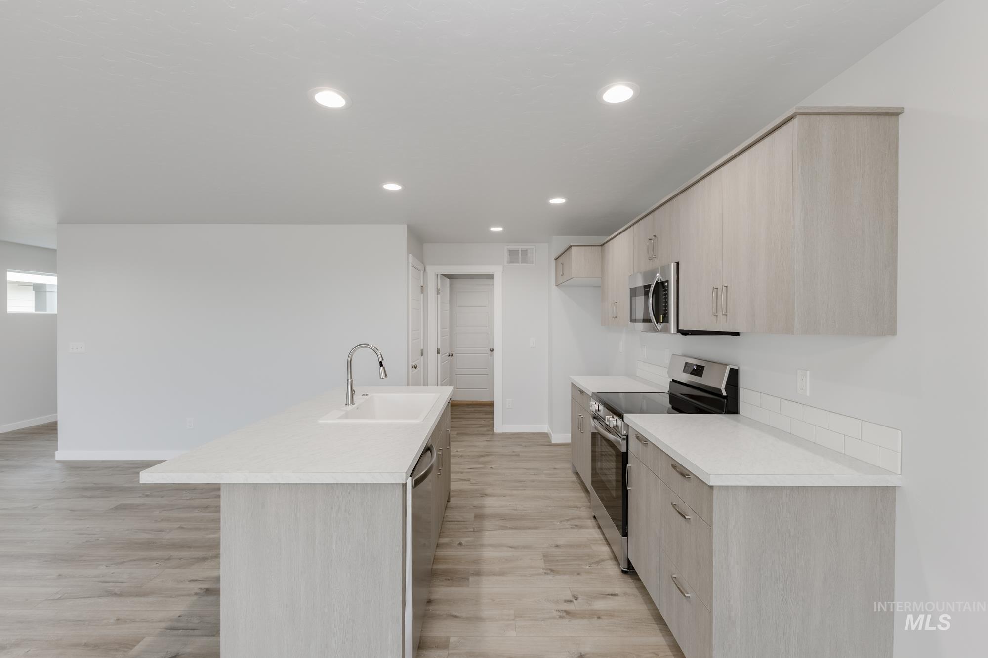 10873 Rutland Street Caldwell, ID 83605 - Photo 5 of 19 Kitchen with light brown cabinetry, modern cabinets, light countertops, and recessed lighting