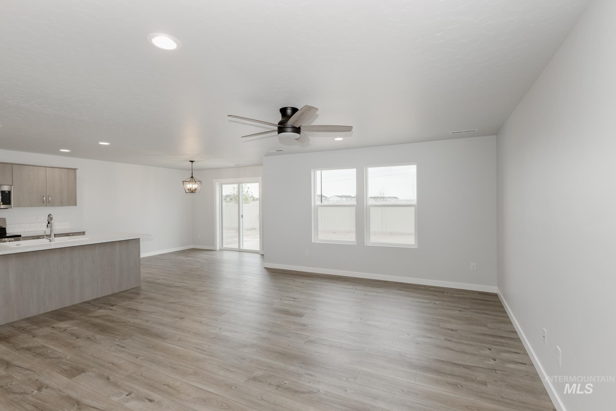 10873 Rutland Street Caldwell, ID 83605 - Photo 7 of 19 Unfurnished living room featuring light wood-style flooring, ceiling fan, and recessed lighting