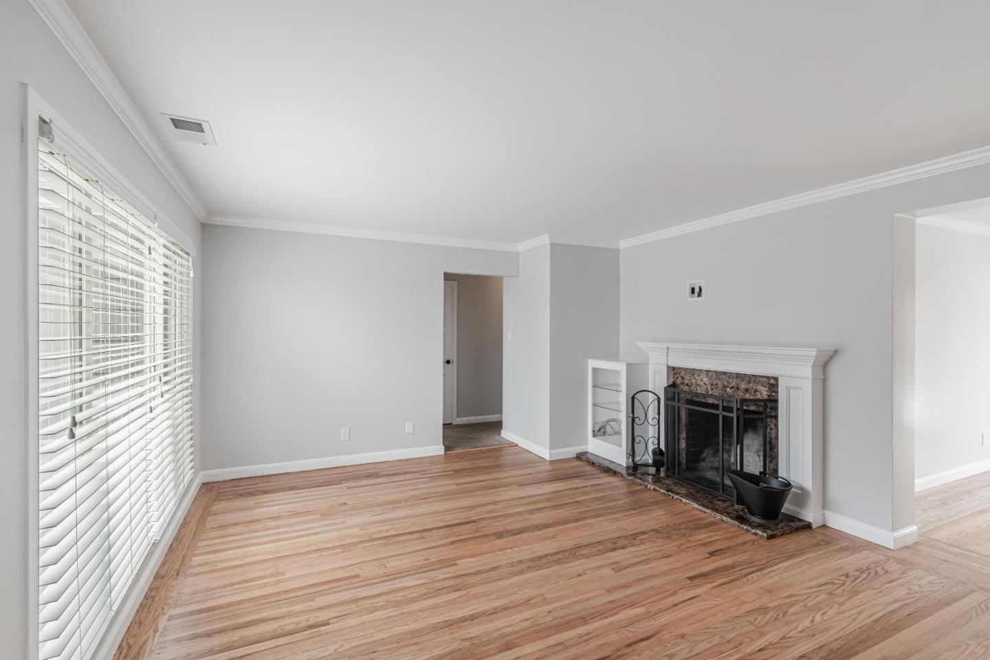 843 Beechwood Drive Daly City, CA 94015 - Photo 3 of 25 an empty room with wooden floor fireplace and windows