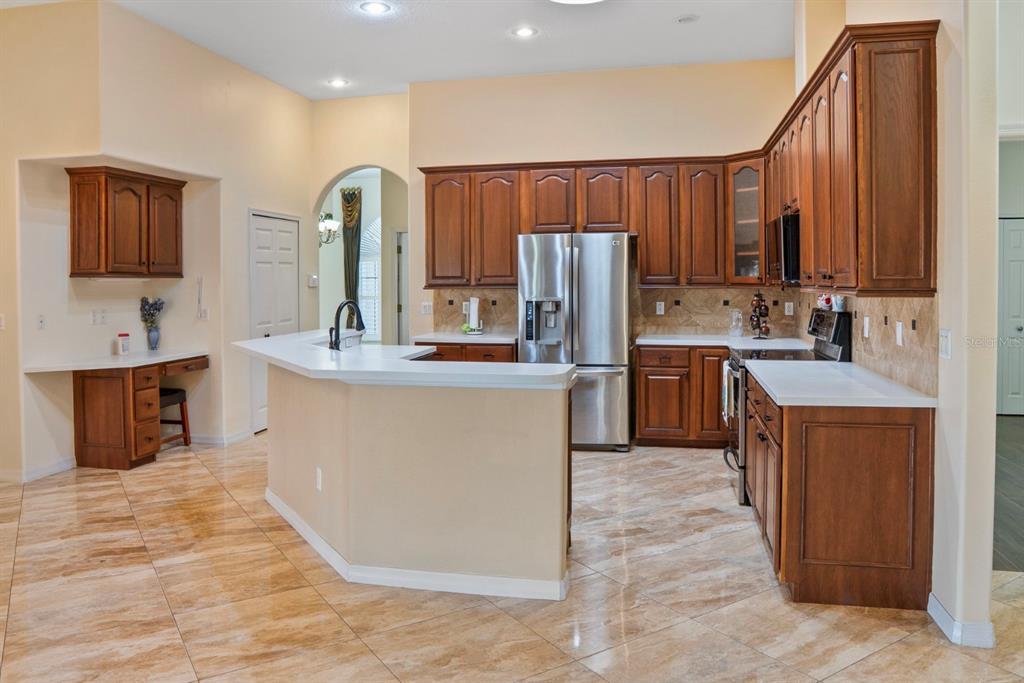 215 Strathmore Circle Kissimmee, FL 34744 - Photo 11 of 24 a kitchen with kitchen island granite countertop a sink and a refrigerator