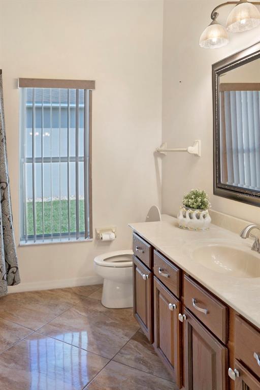 215 Strathmore Circle Kissimmee, FL 34744 - Photo 13 of 24 a bathroom with a sink a toilet and mirror