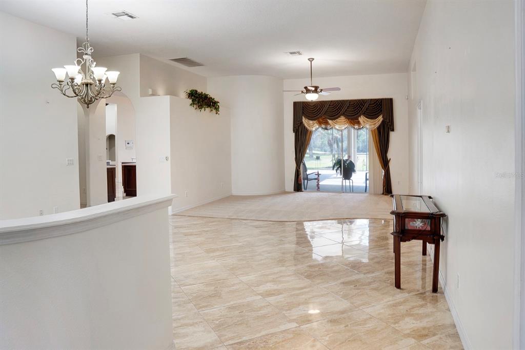 215 Strathmore Circle Kissimmee, FL 34744 - Photo 3 of 24 a view of a dining room with a chandelier and furniture