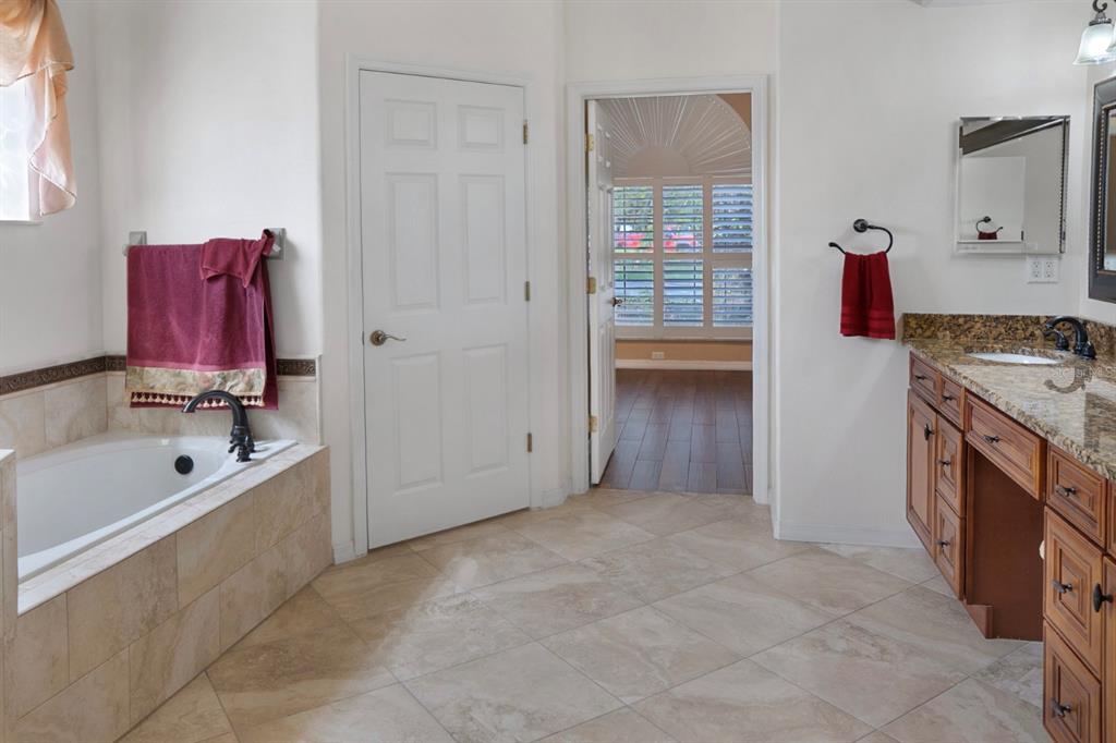 215 Strathmore Circle Kissimmee, FL 34744 - Photo 7 of 24 a bathroom with a tub sink and mirror