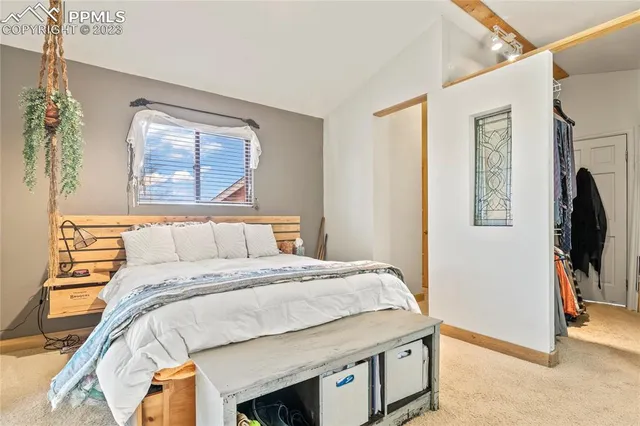 a bedroom with a bed and a flat tv screen on dresser