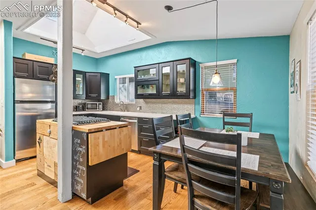 a kitchen with stainless steel appliances kitchen island granite countertop a stove refrigerator and cabinets