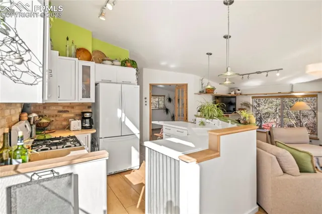 a kitchen with stainless steel appliances kitchen island granite countertop a refrigerator and a stove