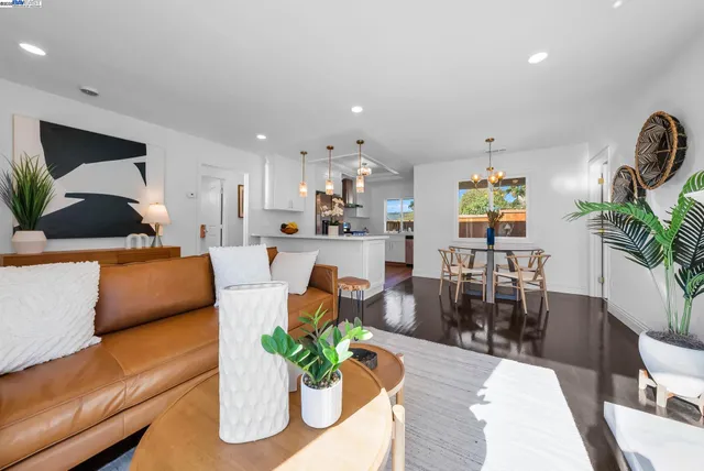 a view of a dining room and livingroom with furniture wooden floor a chandelier