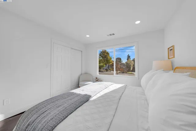 a bedroom with a bed and a painting on the wall