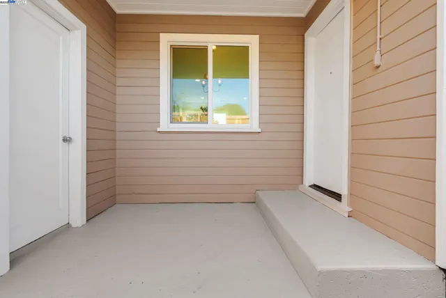a patio with table and chairs and potted plants