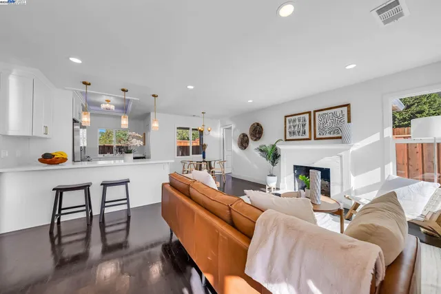 a living room with furniture a fireplace and kitchen view