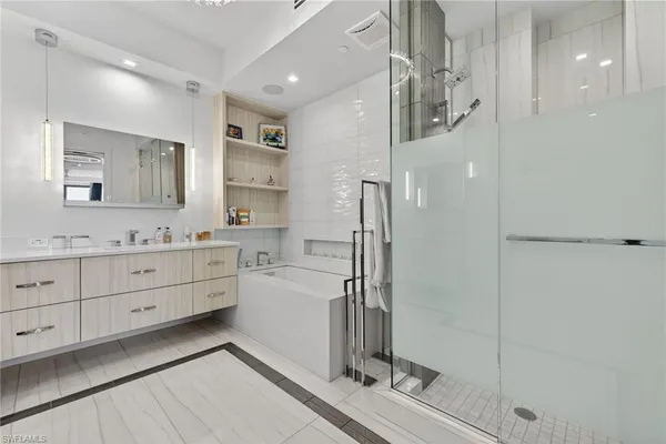 a spacious bathroom with a double vanity sink a mirror and a shower