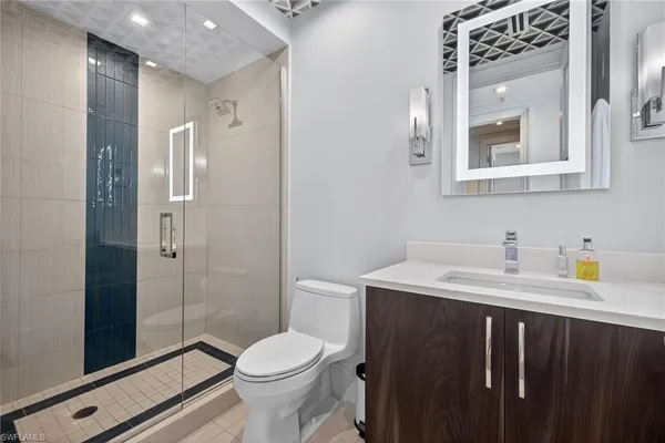 a bathroom with a sink a toilet and shower
