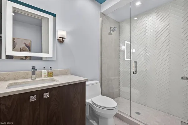 a bathroom with a sink a toilet and shower