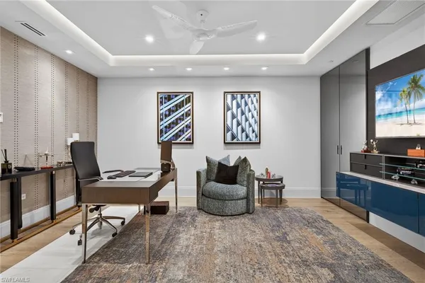 a living room with furniture a flat screen tv and kitchen view