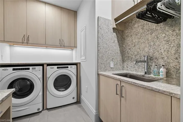 a utility room with sink dryer and washer