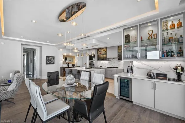 a dining room with stainless steel appliances kitchen island granite countertop a dining table chairs and a oven