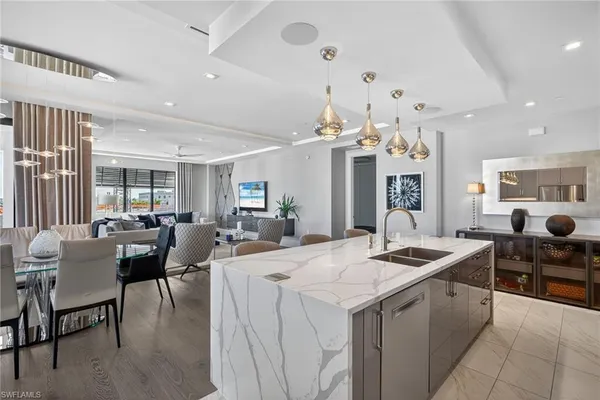 a kitchen with stainless steel appliances kitchen island granite countertop a table and chairs in it