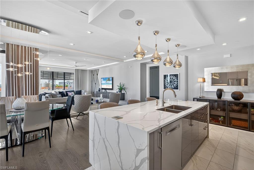1135 3rd Avenue South, Unit 521 Naples, FL 34102 - Photo 7 of 39 a kitchen with stainless steel appliances kitchen island granite countertop a table and chairs in it
