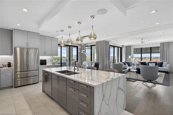 a large kitchen with kitchen island a large counter top space appliances and furniture