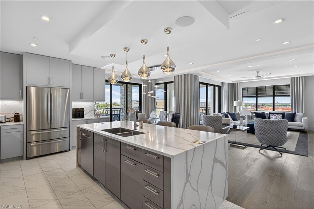 1135 3rd Avenue South, Unit 521 Naples, FL 34102 - Photo 8 of 39 a large kitchen with kitchen island a large counter top space appliances and furniture