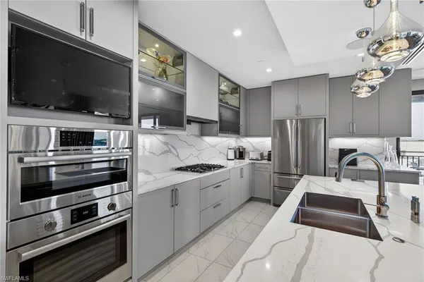 a kitchen with stainless steel appliances kitchen island granite countertop a stove and a sink