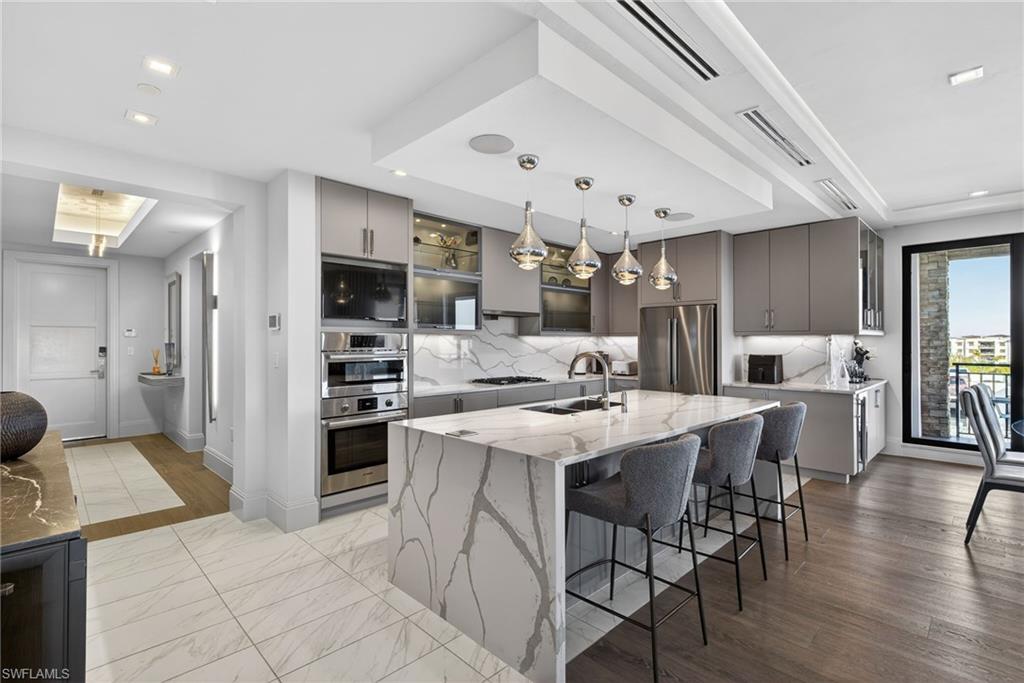 1135 3rd Avenue South, Unit 521 Naples, FL 34102 - Photo 10 of 39 a kitchen with stainless steel appliances kitchen island granite countertop a sink and cabinets