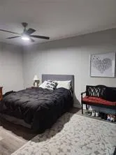 a bedroom with a bed and a lamp on dresser
