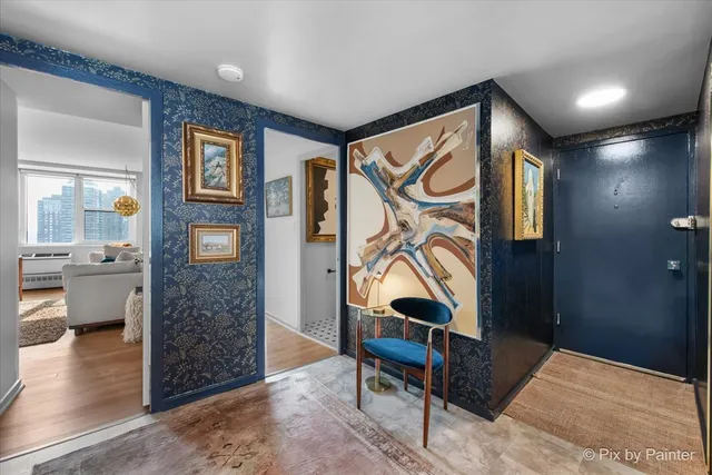 a hall way with furniture a rug and a painting on the wall