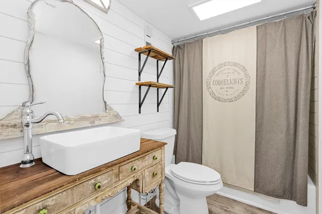 a bathroom with a sink a toilet and a mirror