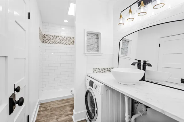 a bathroom with a sink a toilet and shower